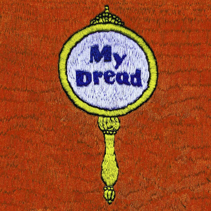 image is of a handheld mirror embroidered onto a furry looking background.